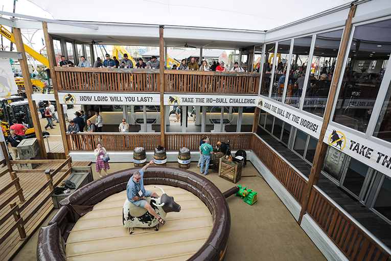 Wide shot of visitor riding an electric bull